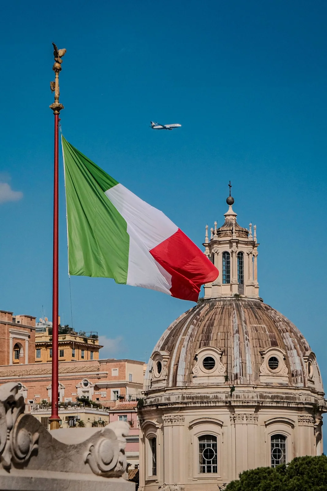 Italian flag over a historic Roman dome